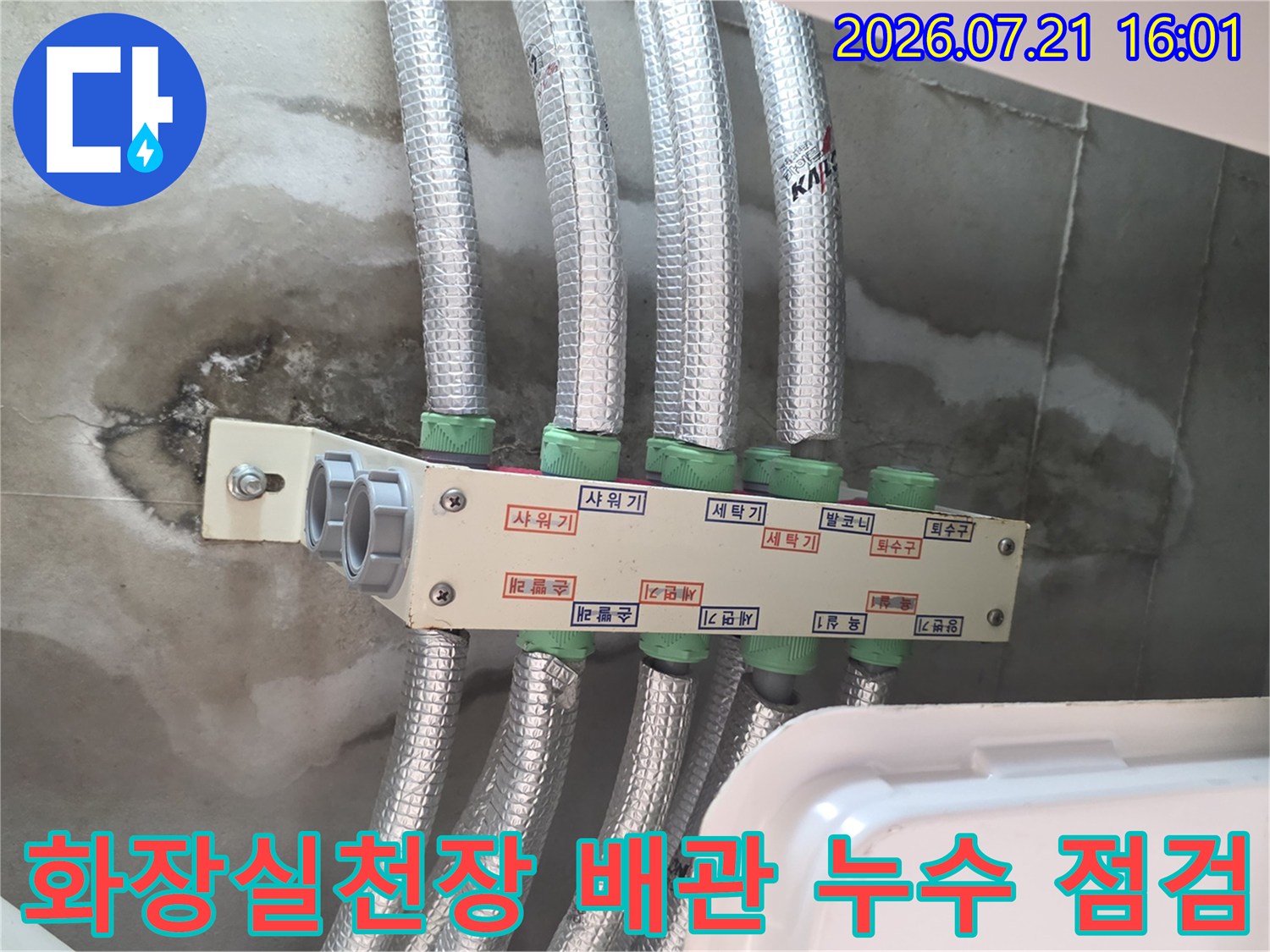 거칠게 마감된 천장면과 노출된 은색 보온재로 감싸진 배관들의 모습