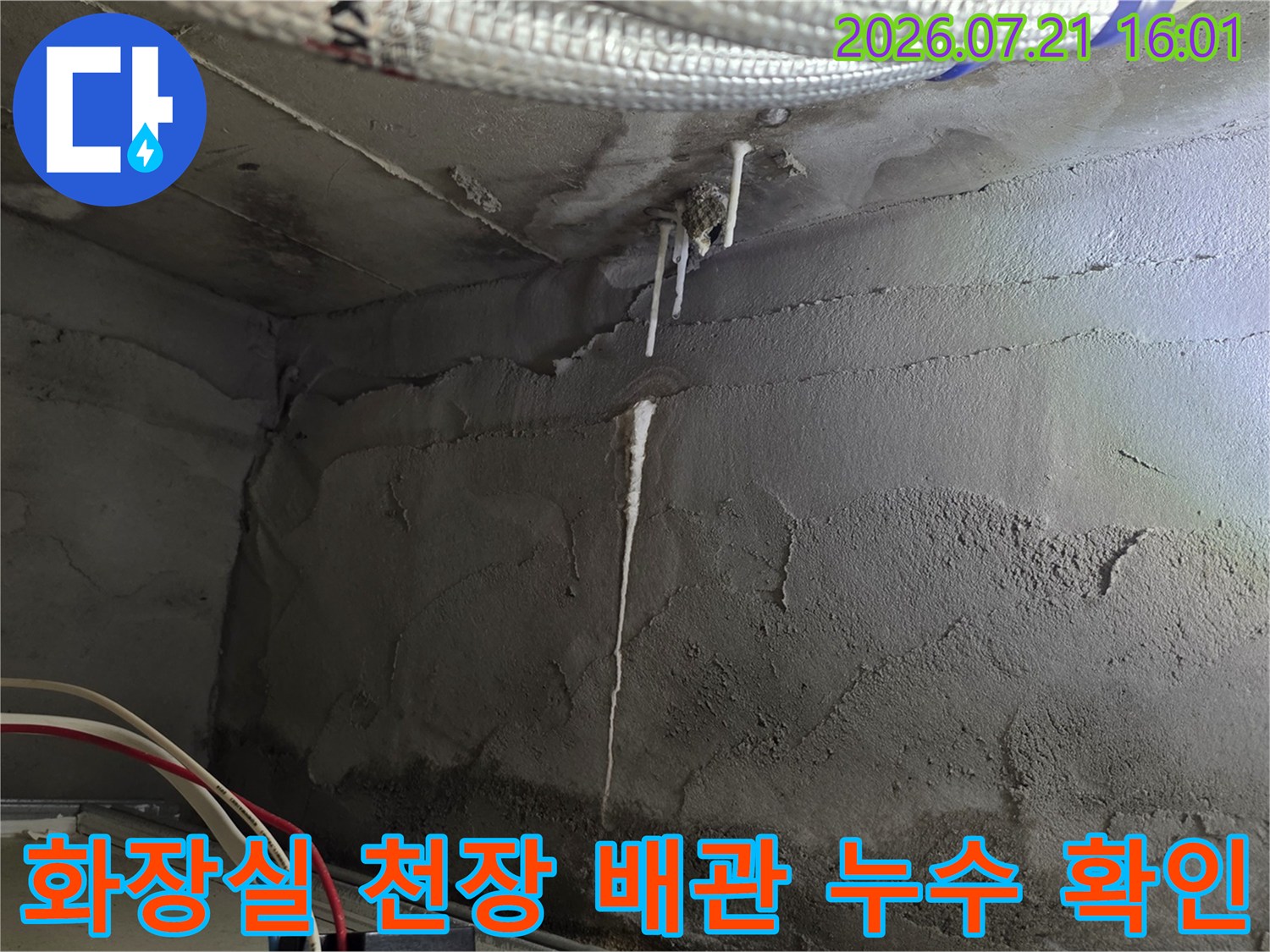 화장실 천장 내부에 노출된 배관과 습기로 인한 변색 부위 점검 장면