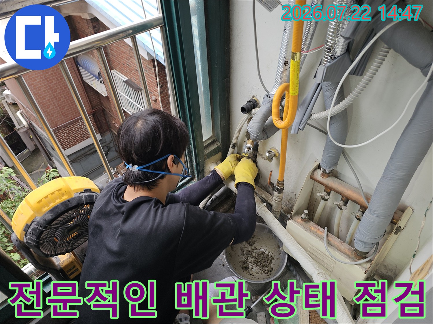 노란색 직수 배관의 문제 부위를 파악하기 위해 집중하는 작업자의 손과 장비