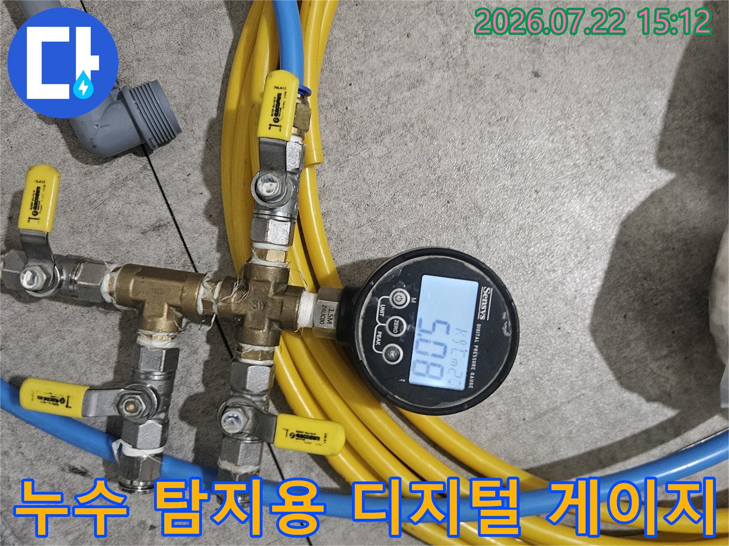 노란색 배관 릴과 파란색 호스가 연결된 정밀 압력 측정 장치