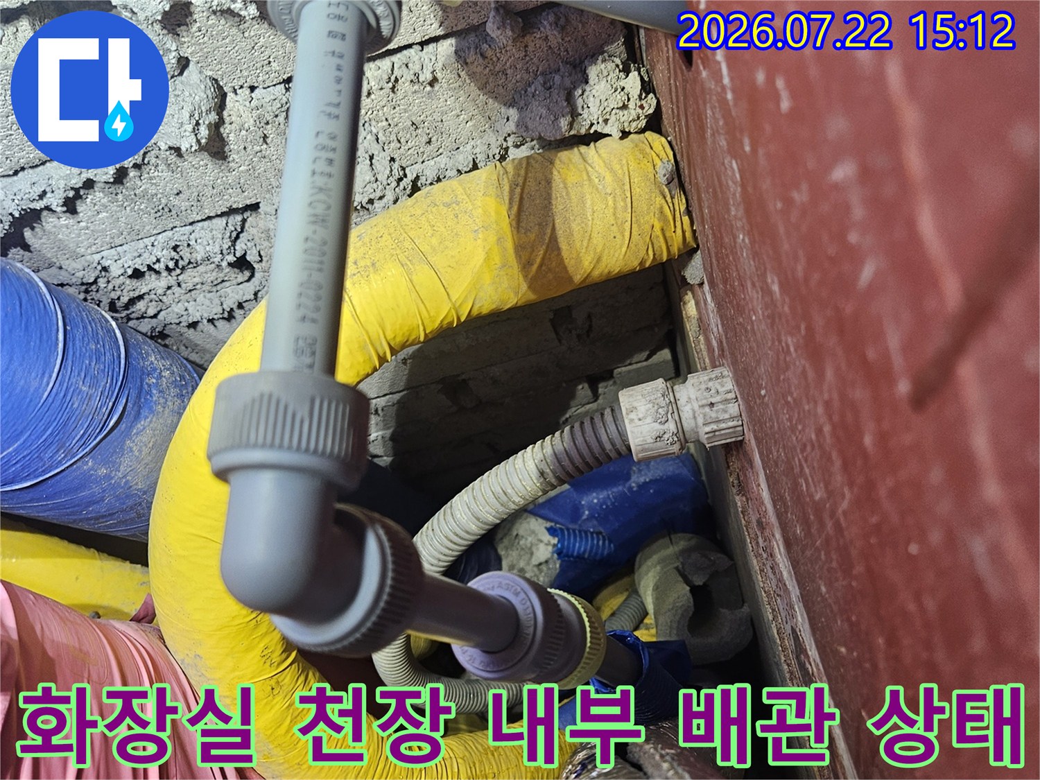 천장 내부에 복잡하게 얽혀 있는 회색과 노란색 배관 연결 부위