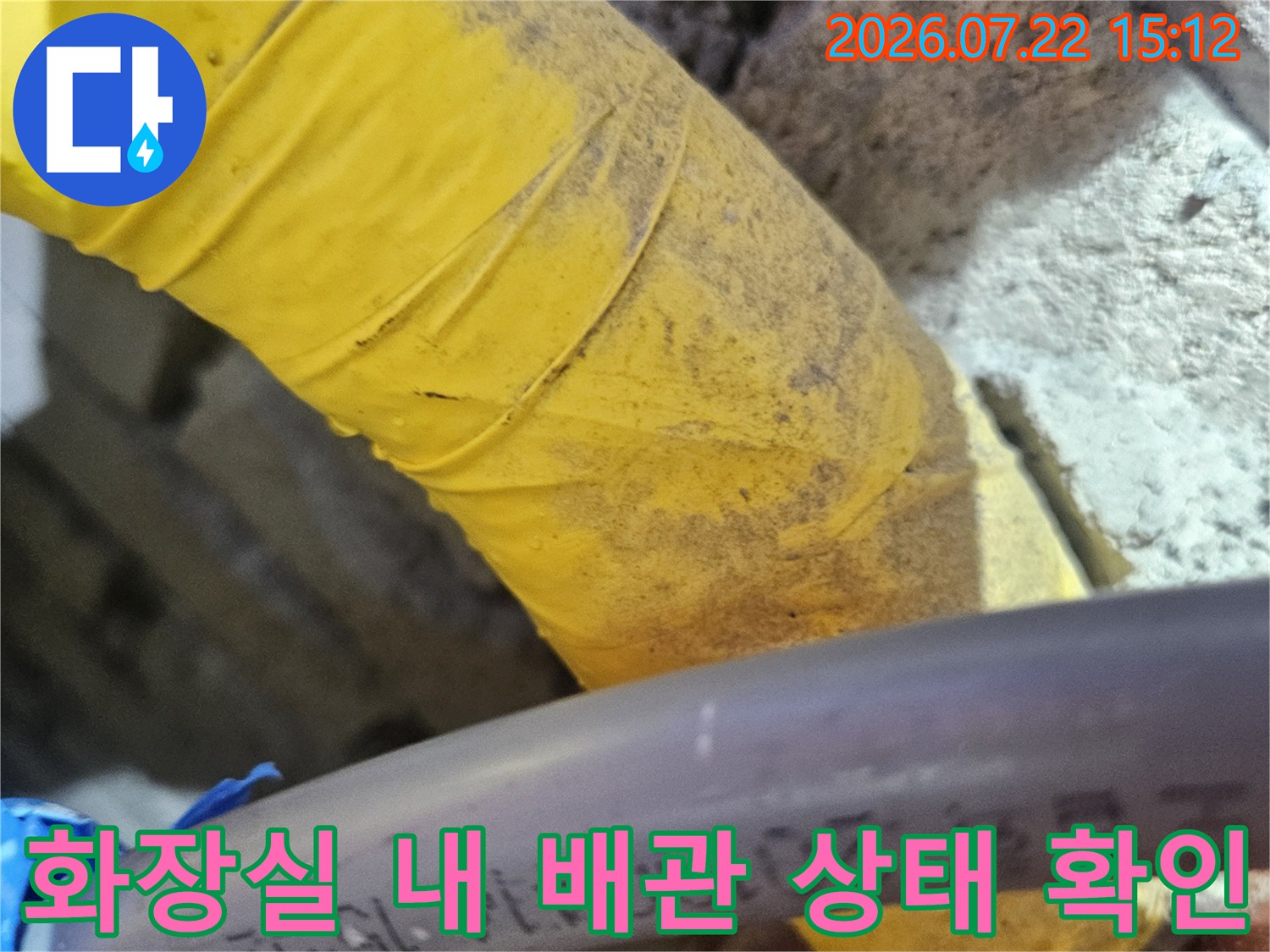 화장실 천장에서 발견된-회색과 노란색의-배관 연결 부위 모습