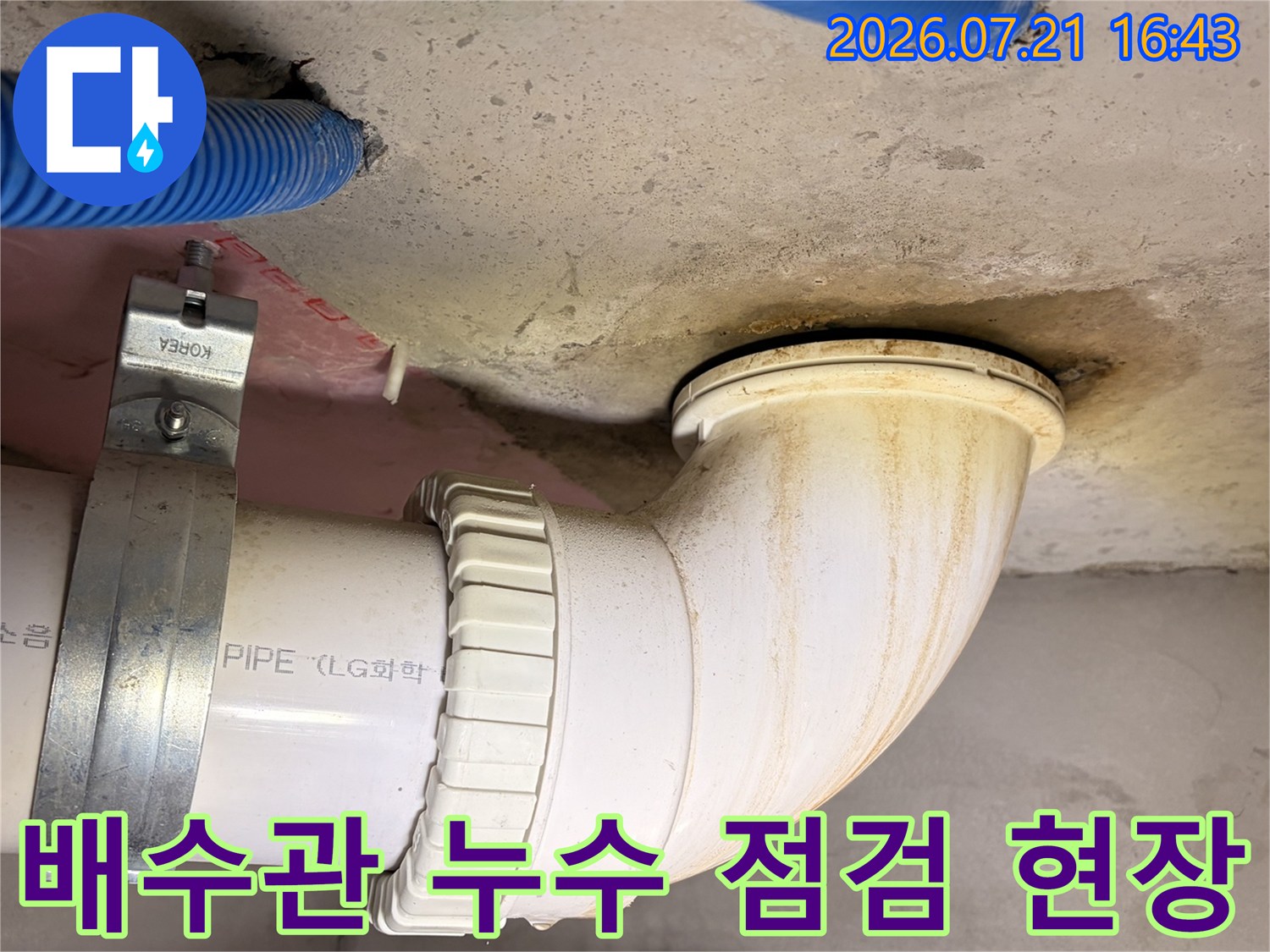 흰색 배수관과 천장 연결 부위의 노후 상태를 점검하는 모습