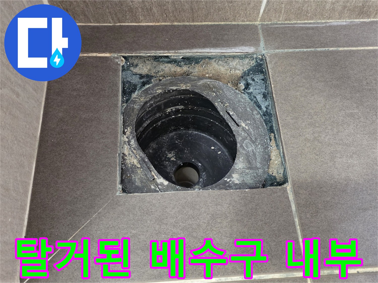 타일 제거 후 드러난 배관 입구와 주변 이물질 상태
