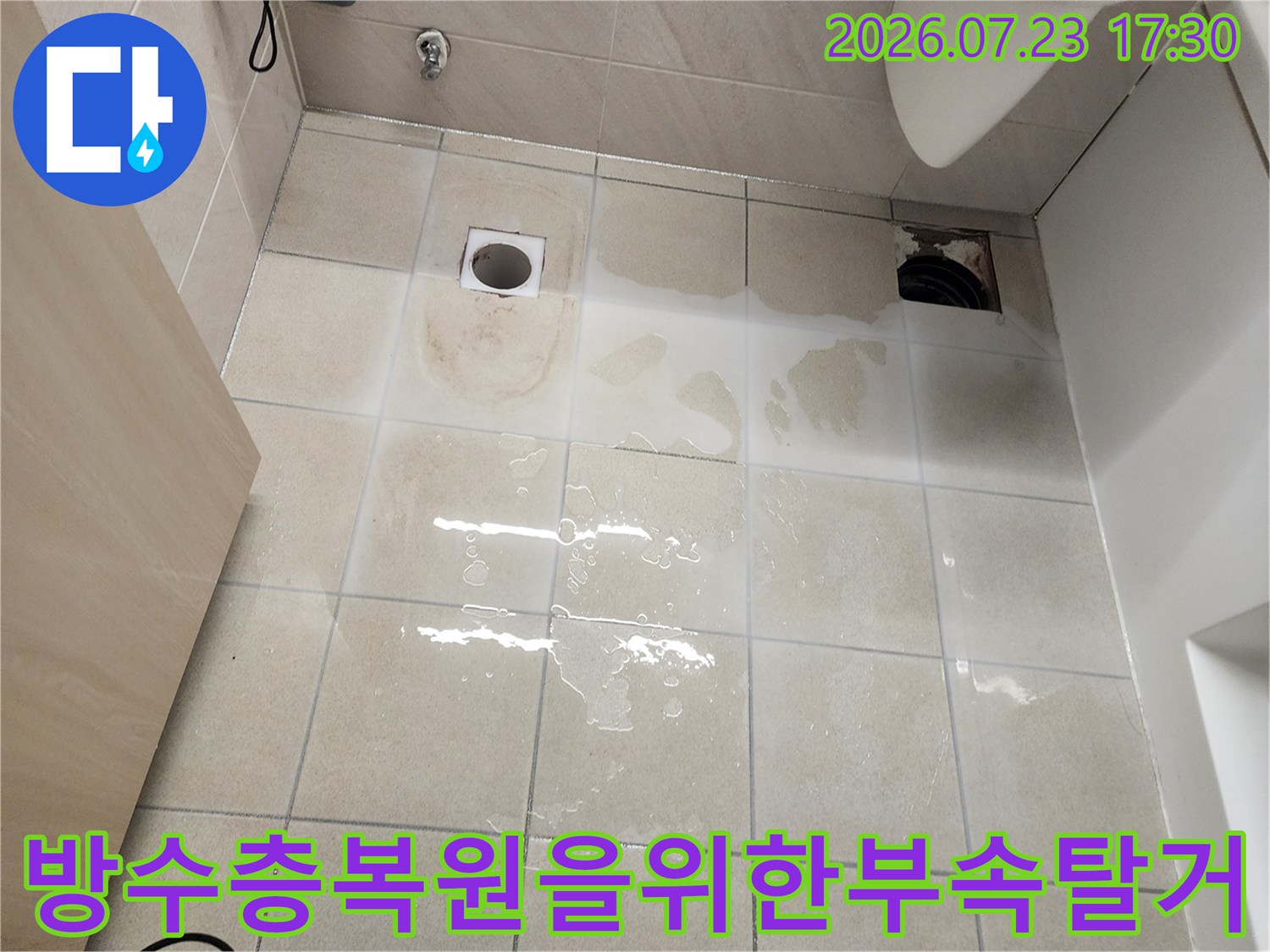 욕실 바닥 타일 위에 변기와 유가가 제거되어 배관 입구가 노출된 사진-방수 공사 준비