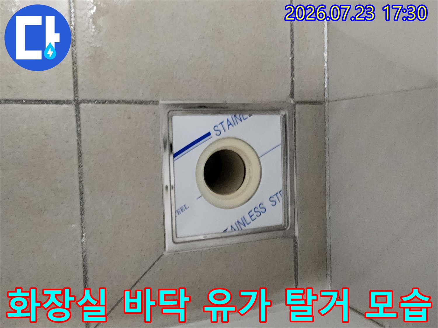 욕실 바닥의 스테인리스 유가가 제거되어 내부 배수관이 드러난 모습