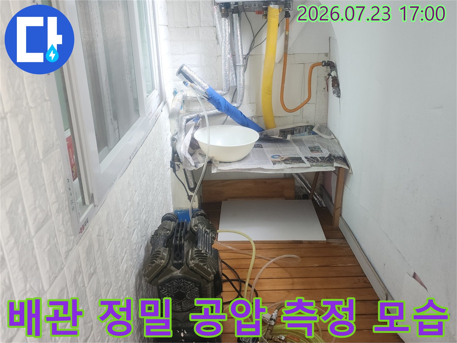 노란색 배관에 연결된 파란색 호스와 압력 게이지-누수 탐지 장비 전경