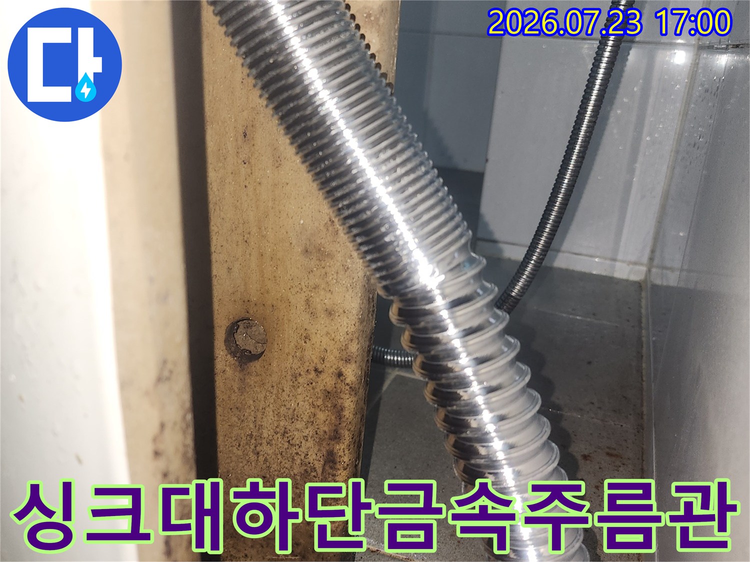 벽면 연결구에 밀착되어 설치된 싱크대용 금속 주름 배관 사진