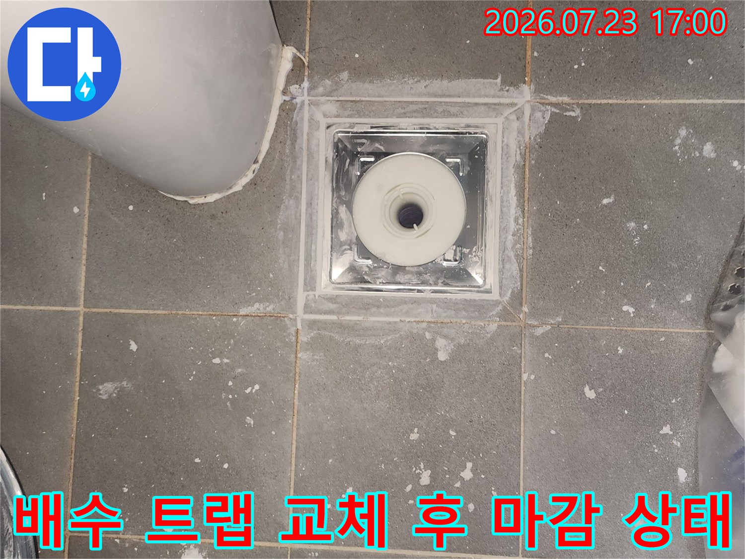 새로 설치된 흰색 배수구-유가와 주변 회색 타일의 접합부 방수 처리