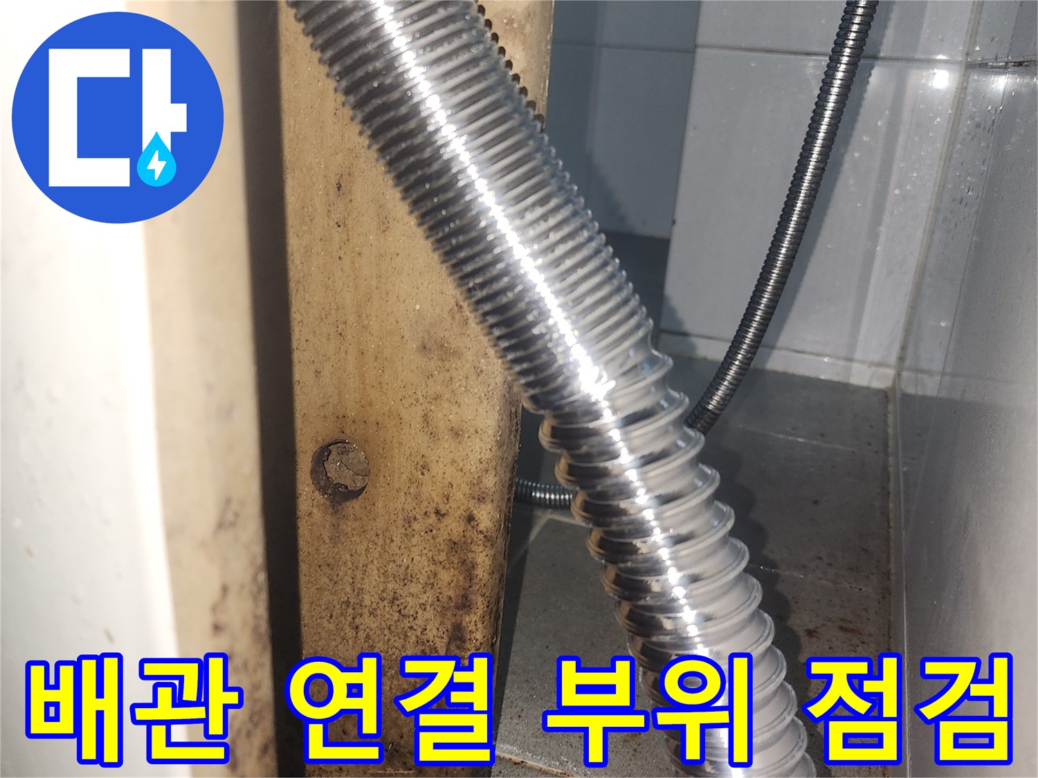 세면대 하단 은색 주름관과 벽체 접합부의 상태를 촬영한 사진