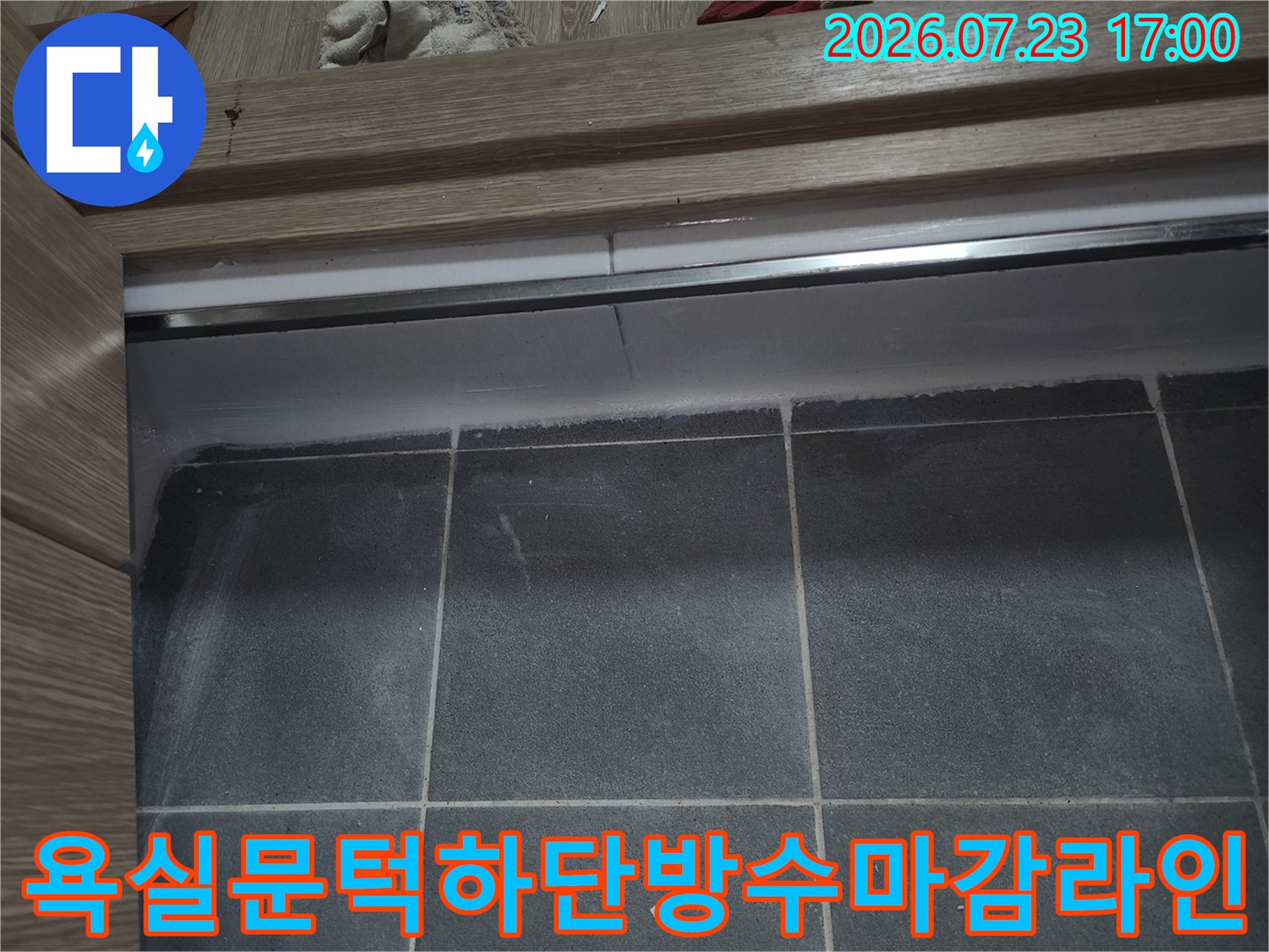 정교하게-시공된-백색-실리콘이-나무-문틀과-회색-타일의-경계를-완전히-덮고-있는-모습