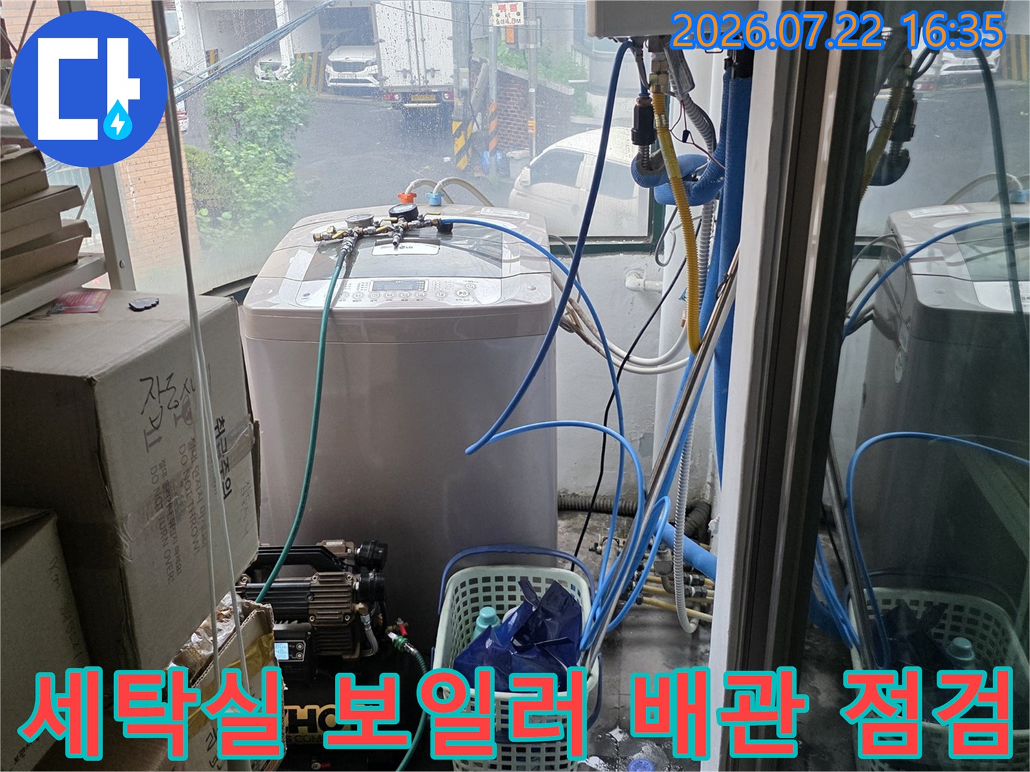 흰색 보일러 본체와 연결된 파란색-투명 배관들이 복잡하게 얽혀 있는 모습