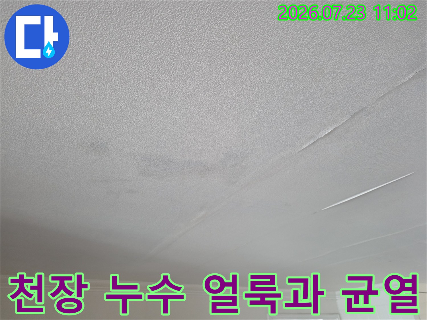 거실 천장 마감재에 발생한 누수 얼룩-습기로 인한 변색과 미세한 균열 현상
