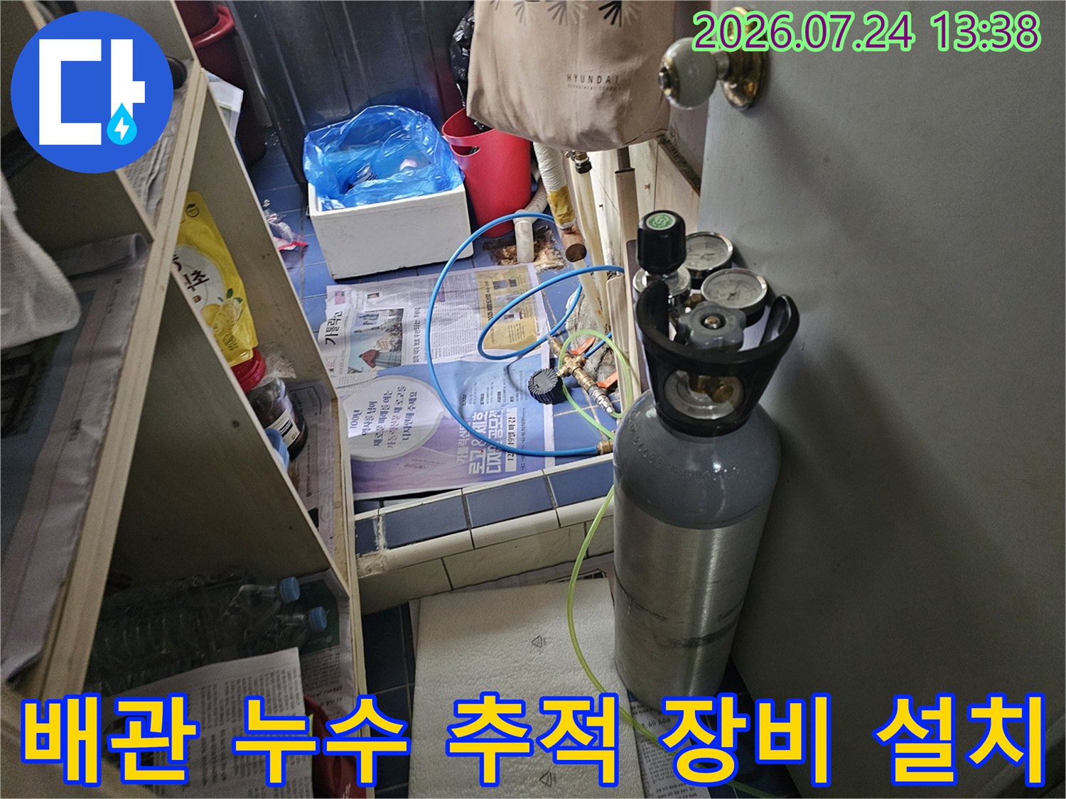 바닥면 위에 놓인 회색 가스 탱크와 연결된 파란색 및 연두색 호스-사진