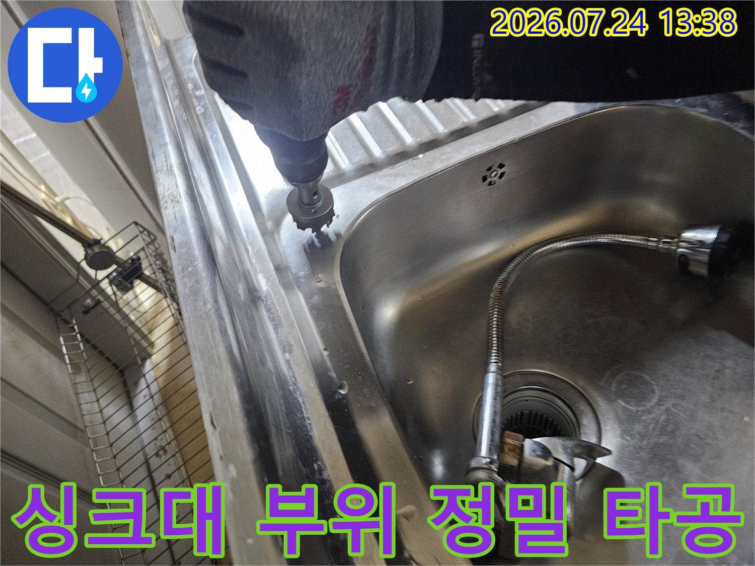 보호 장갑을 착용한 작업자가 전동 툴로 싱크대의 금속 상판 부분을 조심스럽게 뚫고 있는 장면
