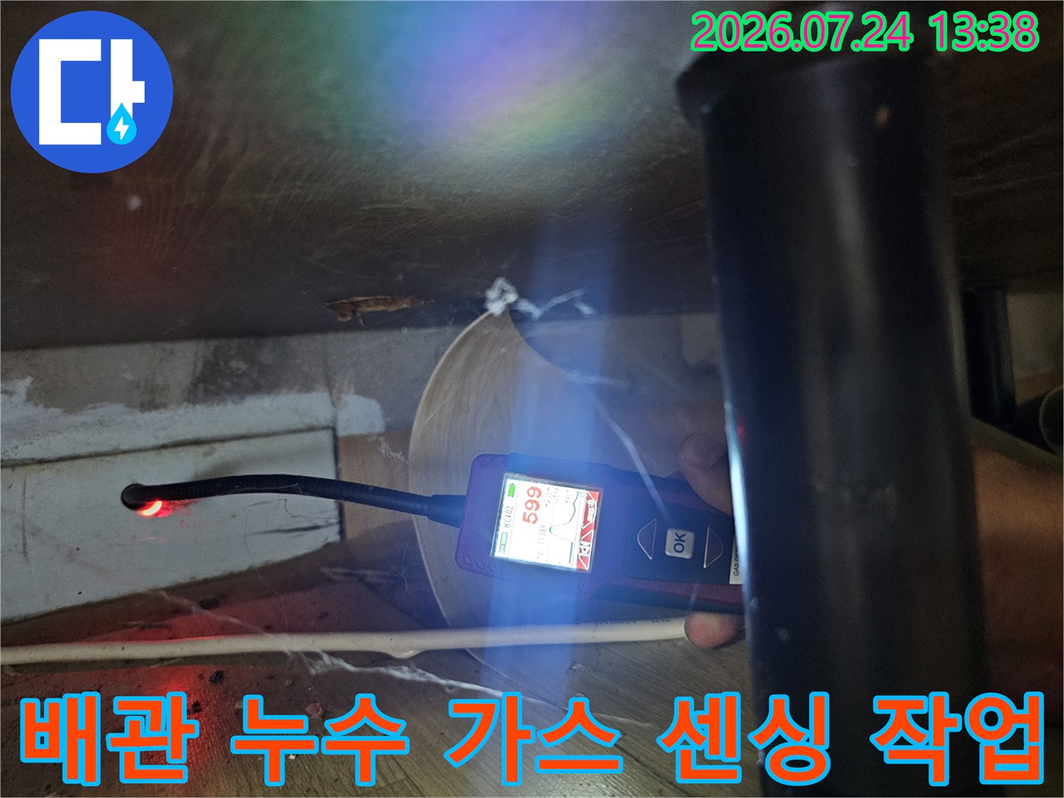 어두운 공간에서 탐지 장비를 사용하여 배관의 가스 누출 여부를 점검하는 모습