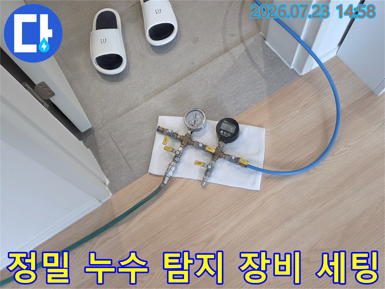 바닥면에서 파란색 호스와 초록색 호스가 분기되어 압력계로 연결된 측정 장치