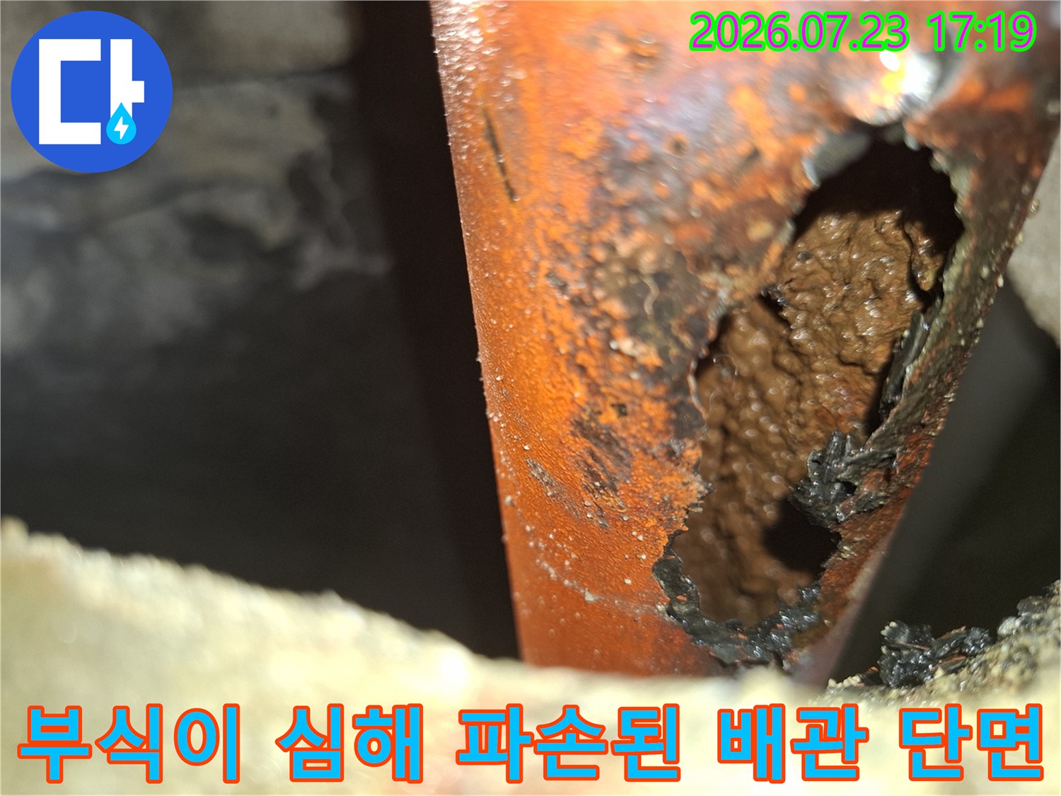 심한 부식으로 인해 껍질이 벗겨지고 구멍이 크게 뚫린 주황색 배관 외벽