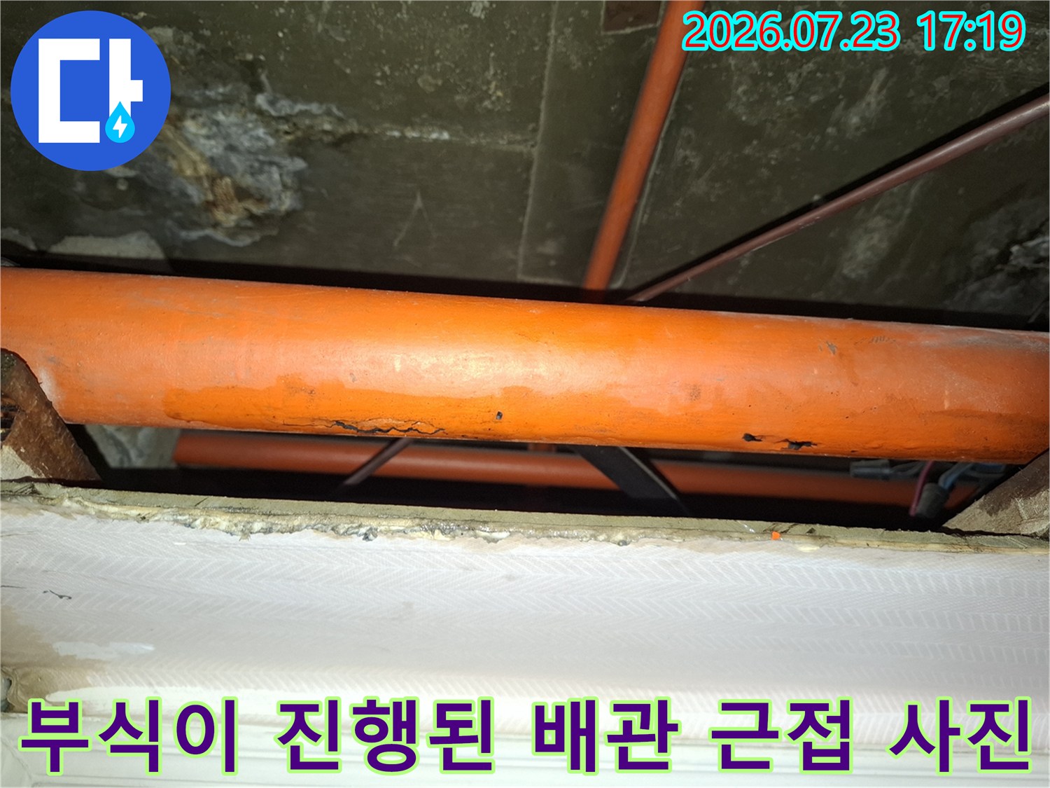 오렌지색 배관 표면에 부식으로 인한 변색과 손상이 나타난 누수 현장-배관 상태 확인