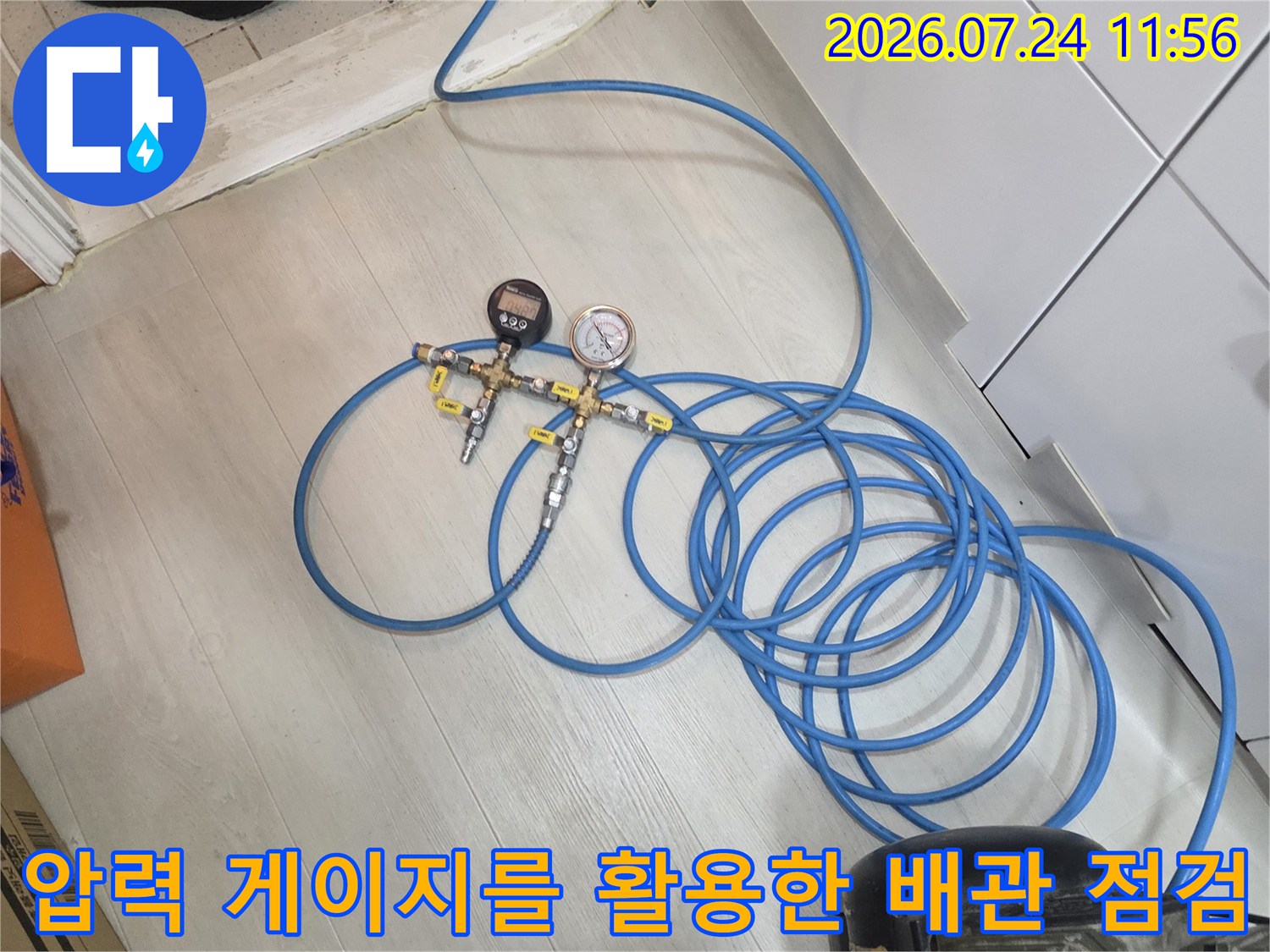 전문 장비와 배관을 연결하여 정밀한 압력 테스트를 진행하는 과정