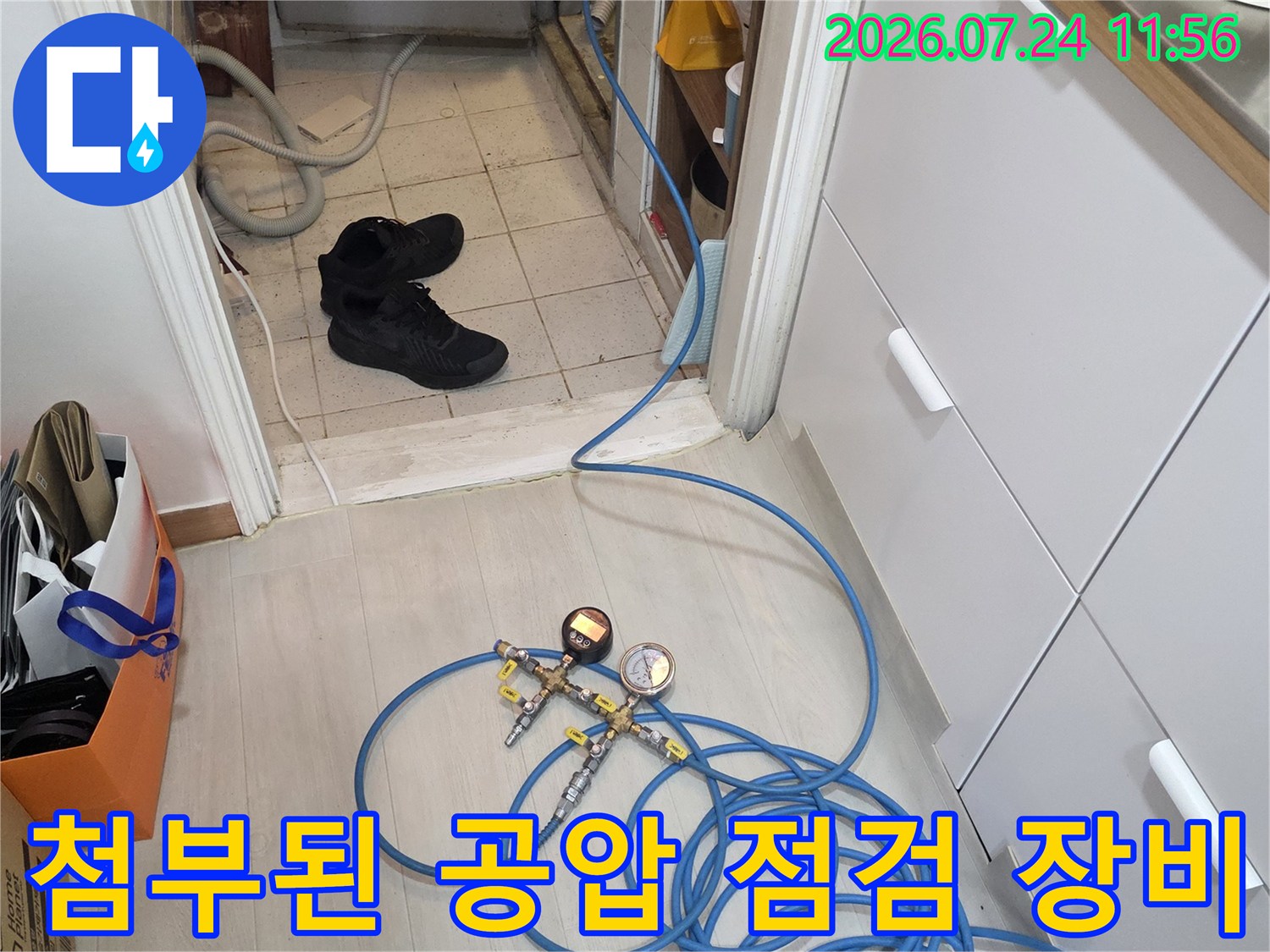파란색 호스와 압력 게이지를 사용하여 배관의 누수 여부를 정밀하게 체크하는 현장 모습입니다.