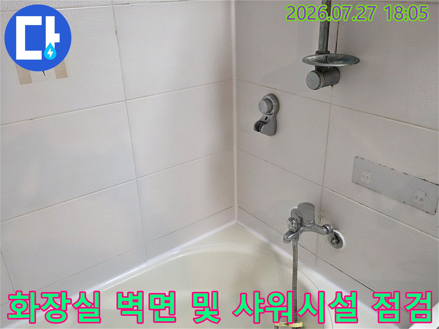 샤워 수전과 흰색 타일-욕조가 배치된 화장실 내부의 전반적인 모습