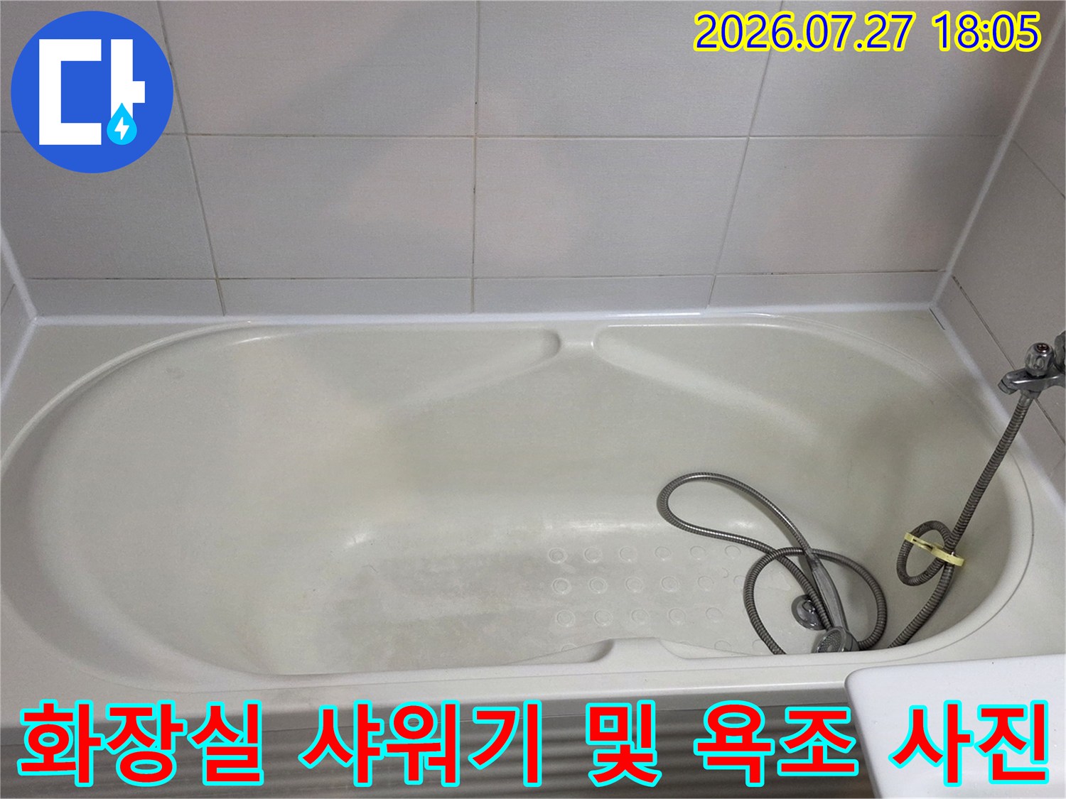 욕조 안에 놓인 샤워 호스와 벽면에 부착된 수전 장치 모습