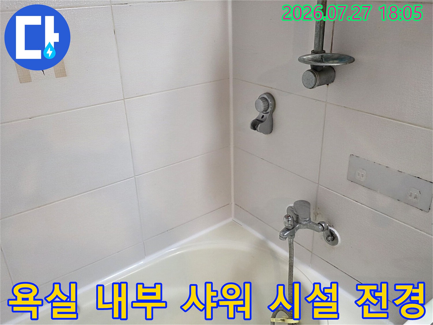 흰색-세라믹-타일-벽면과-금속제-샤워-수전이-설치된-모습