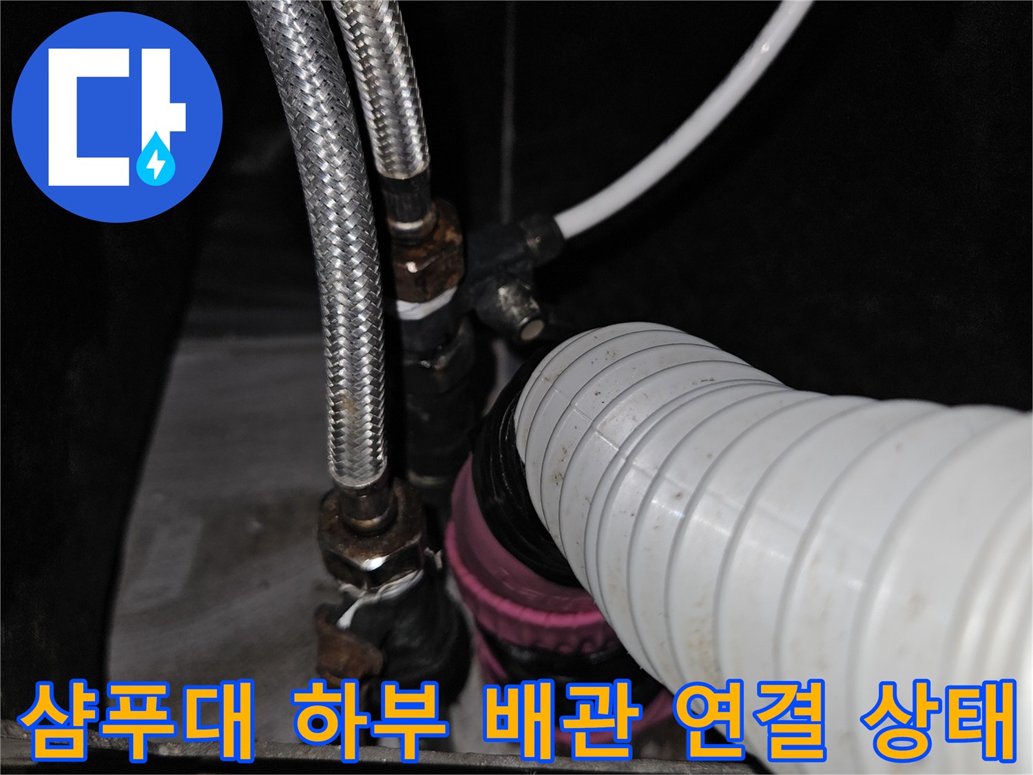미용실 샴푸대 아래쪽의 은색 스테인리스 호스와 흰색 급수 호스 연결 부위 모습