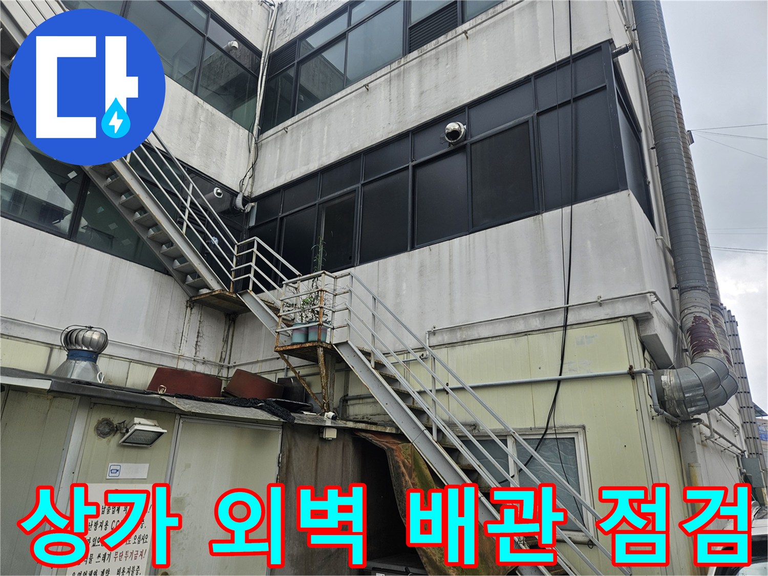 상가 건물 측면의 외부 배관 및 구조물 근접 촬영