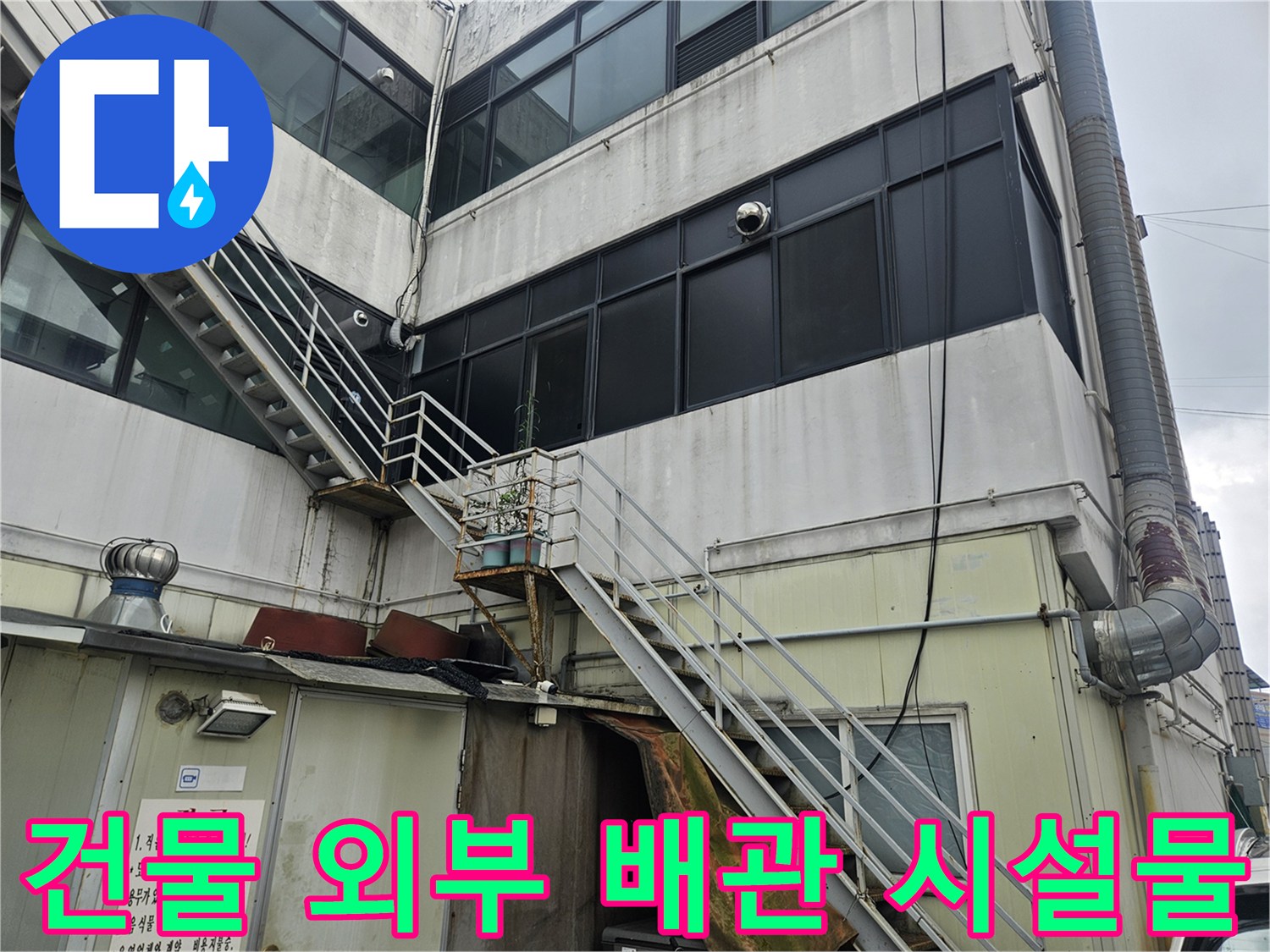 상가 건물의 외벽 배관과 금속 구조물 전체 모습