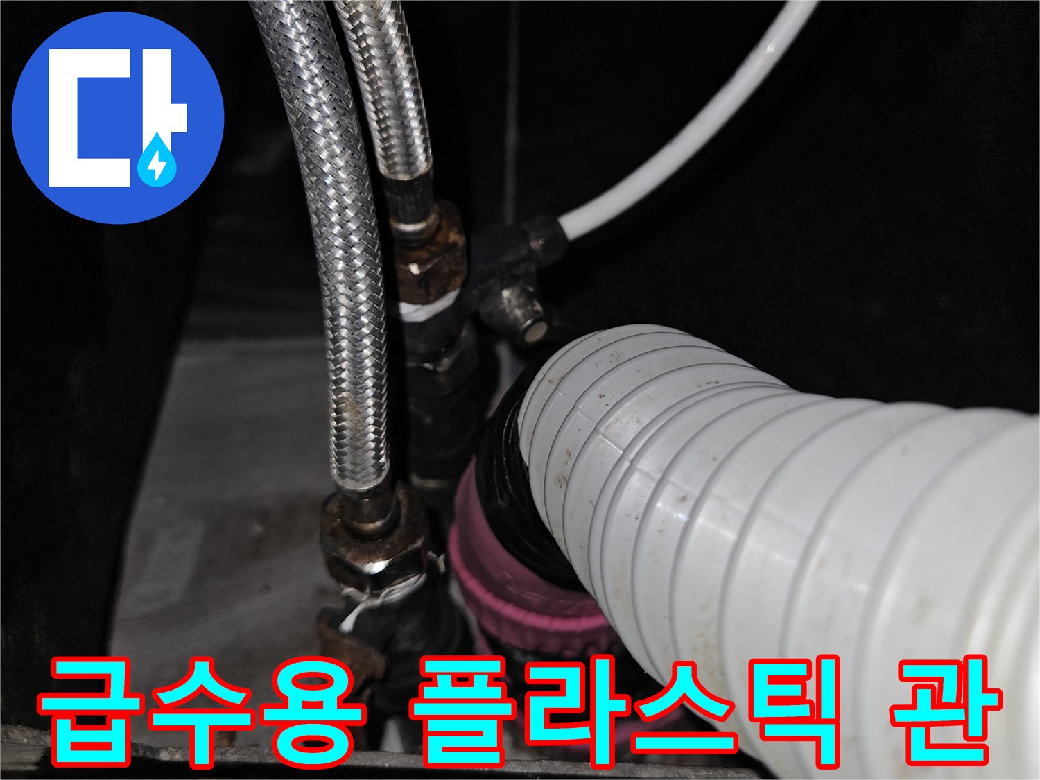 샴푸대 하부의 흰색 플라스틱 배관과 금속 호스 연결 부위