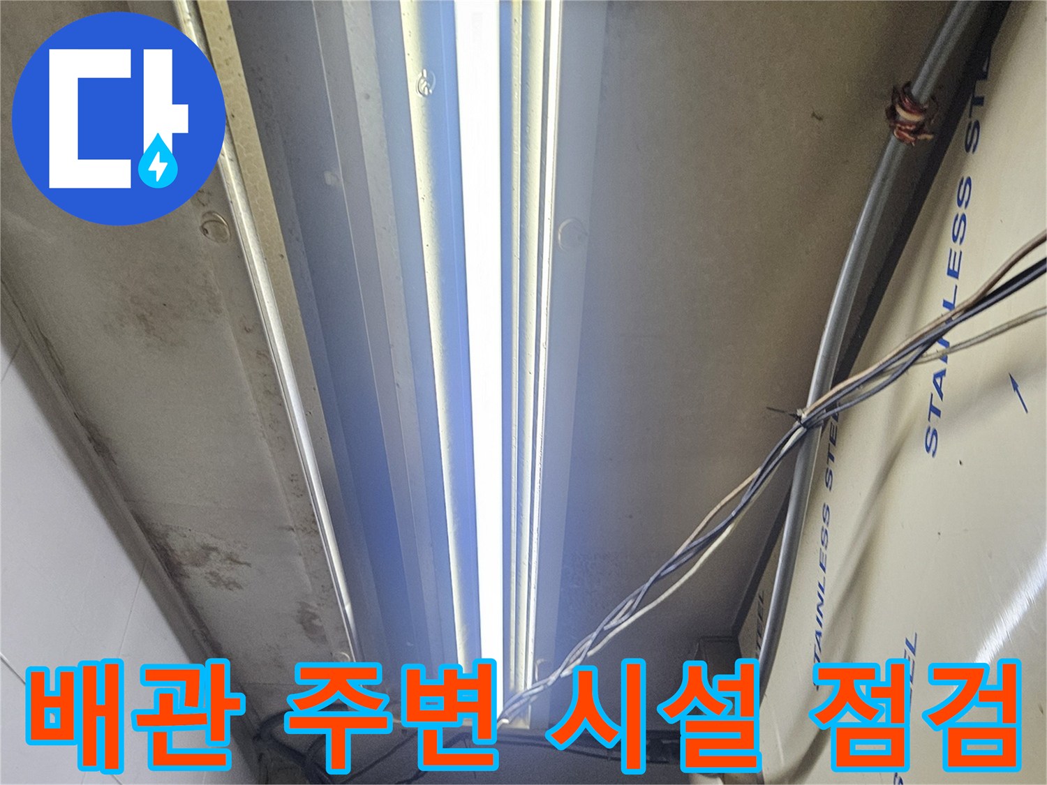 스테인리스 판넬 마감재와 내부로 연결된 전선 및 구조물 사진입니다.