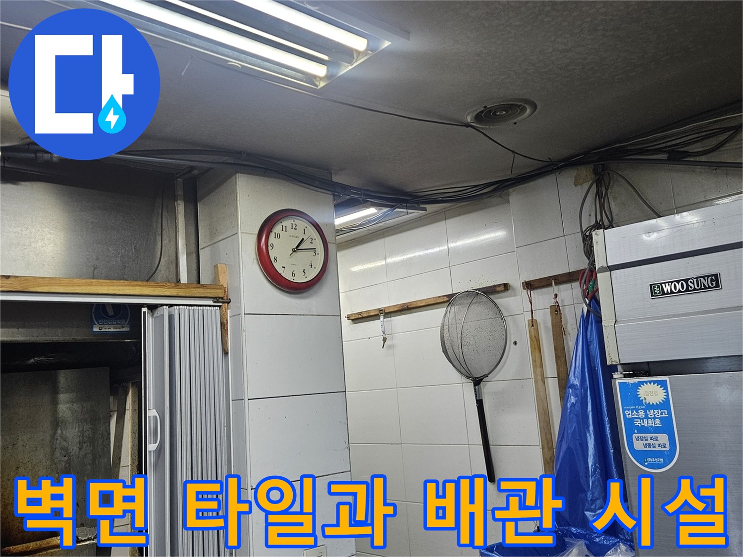 하얀색 타일 벽면과 상업용 냉장고가 배치된 미용실 내부 모습