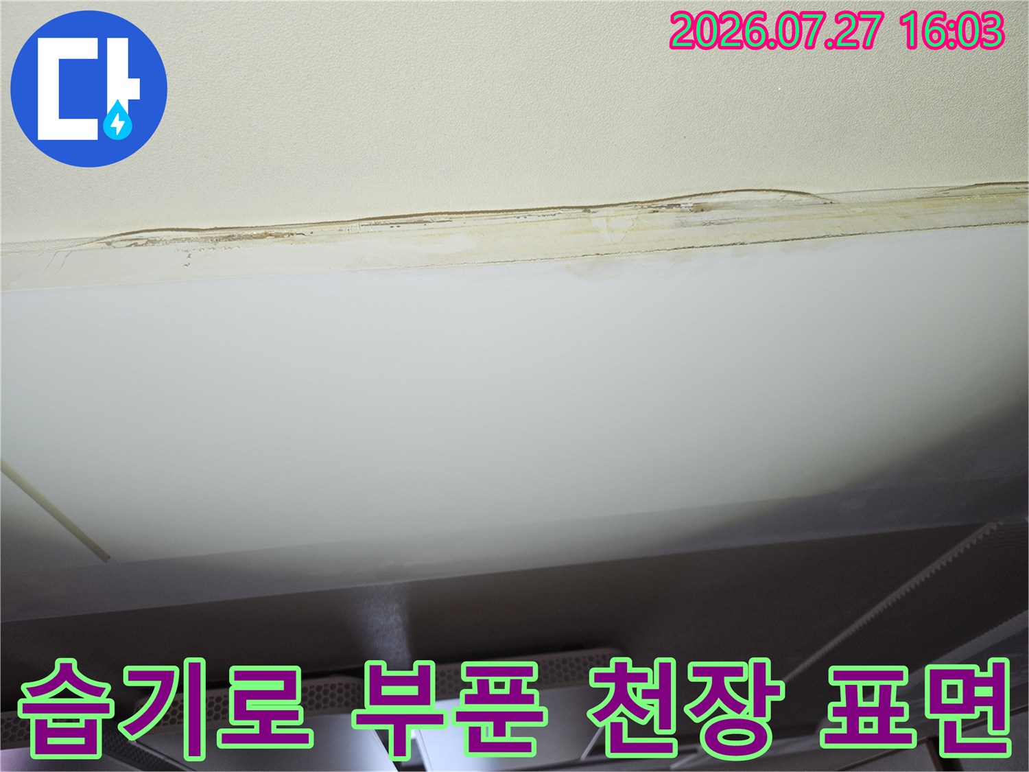 누수로 인해 젖어서 모양이 변하고 색이 변한 거실 천장의 마감 처리 부분