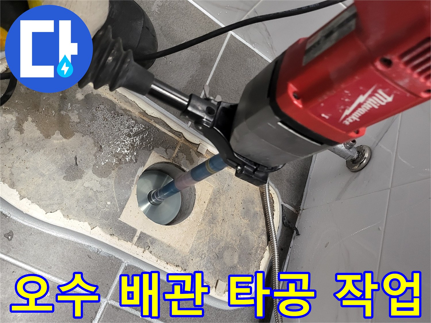 밀워키 함마드릴을 사용하여 오수 배관 부위를 정밀하게 타공하는 모습