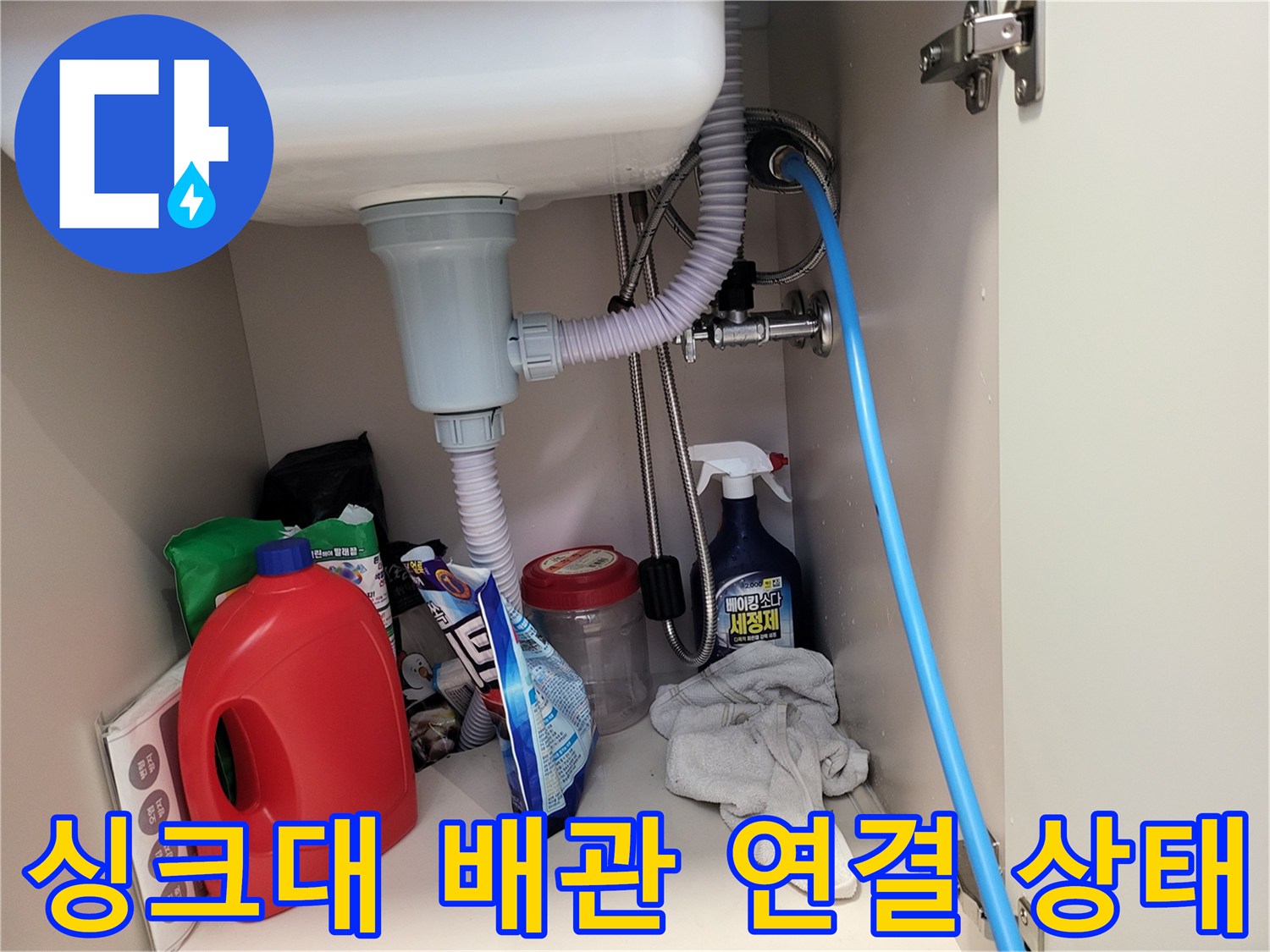 싱크대 하부 배수 호스와 벽면 급수 밸브의 연결 모습