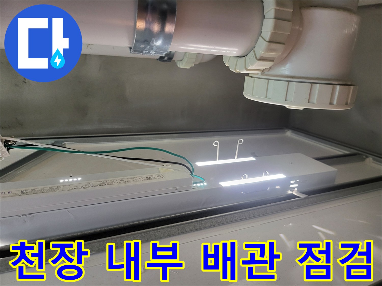 욕실 천장 안쪽의 오수 관로와 조명 시설물 근접 촬영