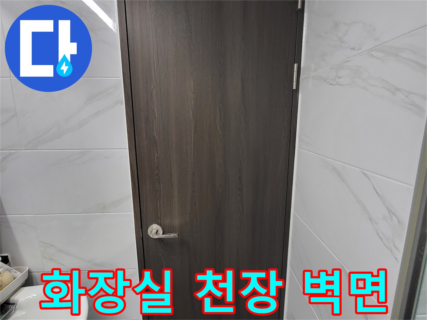 인천 연수구 화장실의 대리석 무늬 타일과 어두운색 상부장 모습입니다.