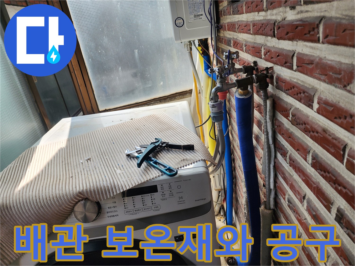 세탁기 상단의 렌치와 벽면의 파란색 배관 라인
