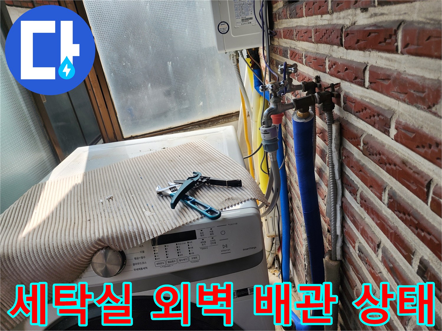 세탁기 옆 외벽에 노출된 파란색 보온재 배관과 밸브 부속품들