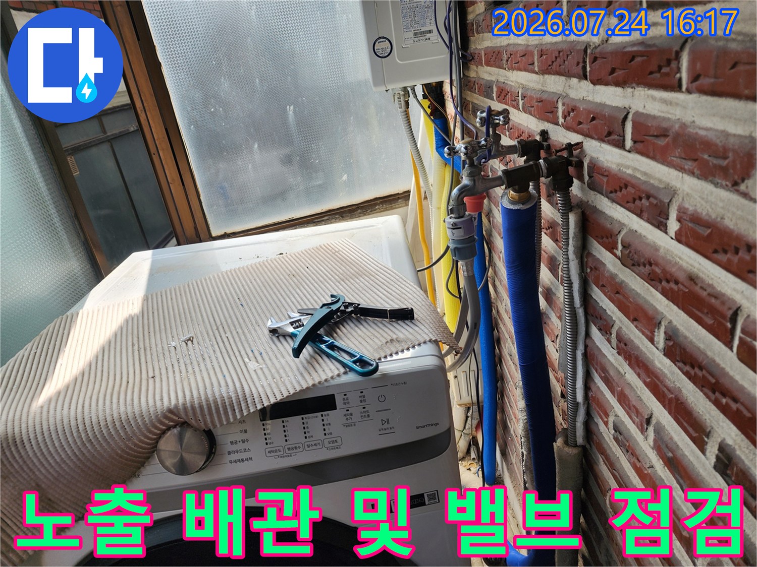 파란색과 은색 단열재로 마감된 수도 배관의 밸브 연결부 점검 장면