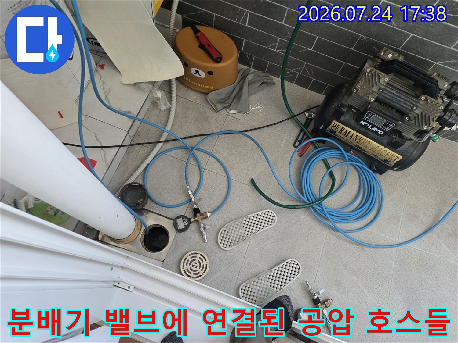 공압용 파란색 호스를 분배기에 연결하여 누수 여부를 정밀 점검하는 기술적 과정