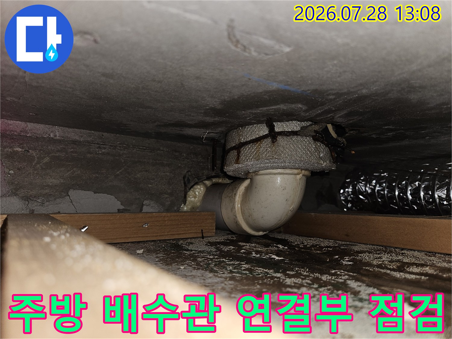 주방 하부의 굴곡진 배수관과 연결 부위 점검 모습