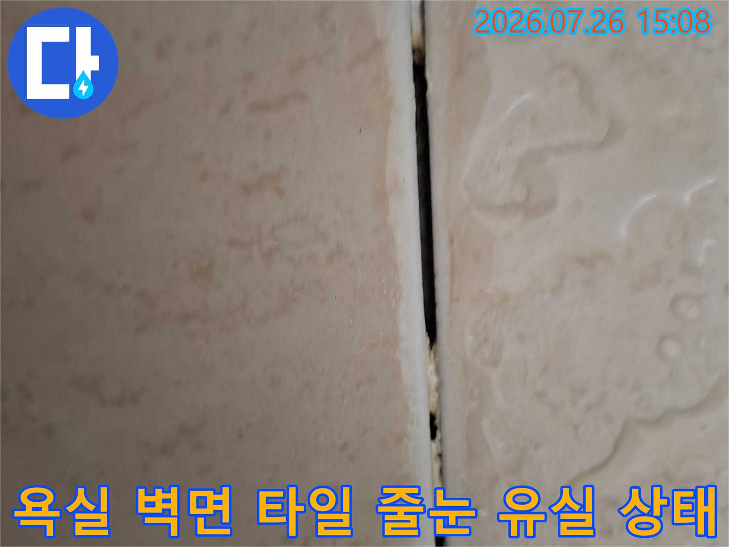베이지색 욕실 타일의 가로 줄눈 부위가 파여 있어 내부가 드러난 모습