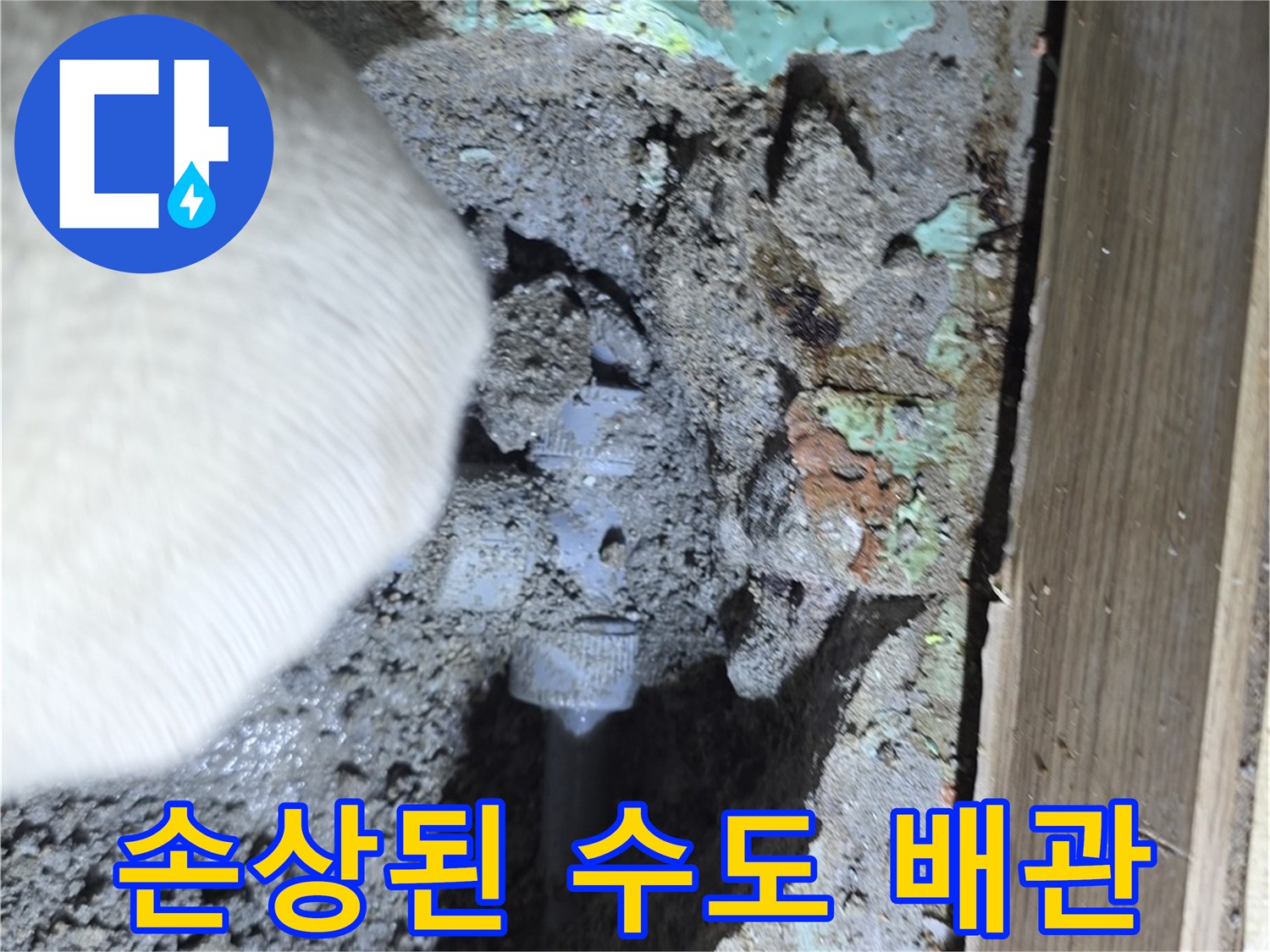 흙과 자재 사이에 노출된 파손된 에이콘 배관 부위