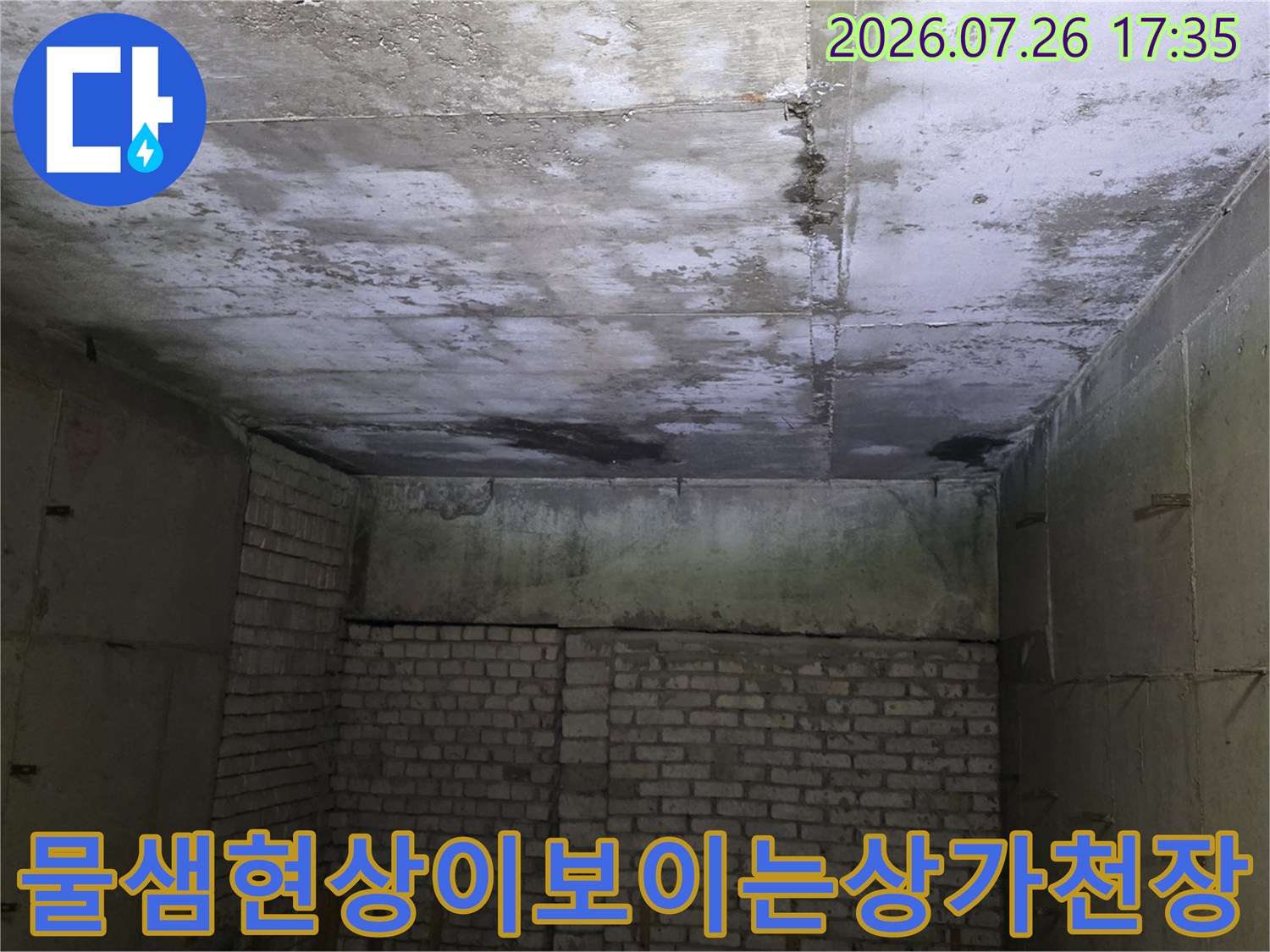 윗층 누수로 인해 콘크리트 천장이 젖어 얼룩덜룩하게 변한 상가 내부 사진
