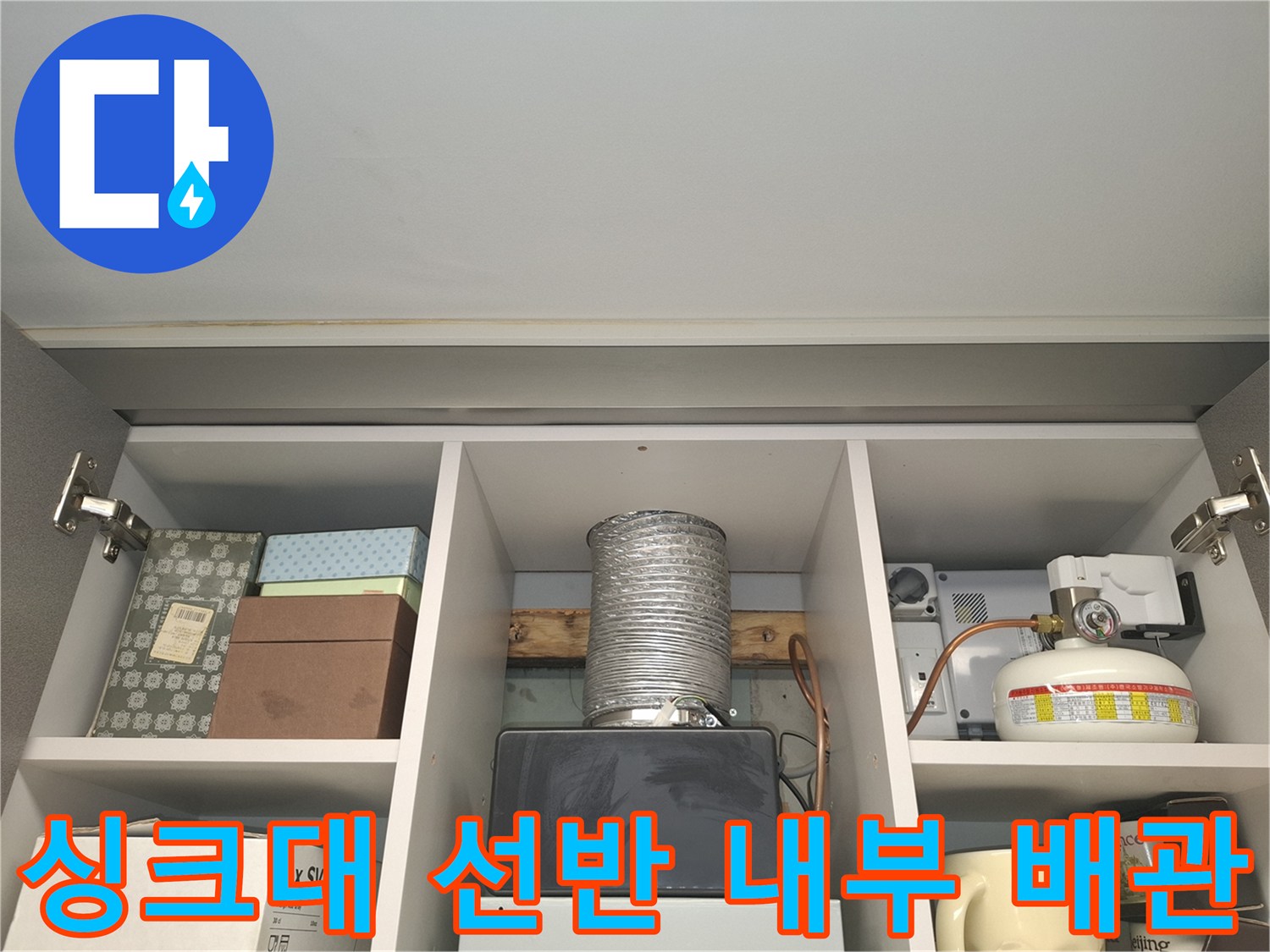 주방 상부장 선반 뒤쪽의 배관 구조와 연결 상태를 점검하는 장면
