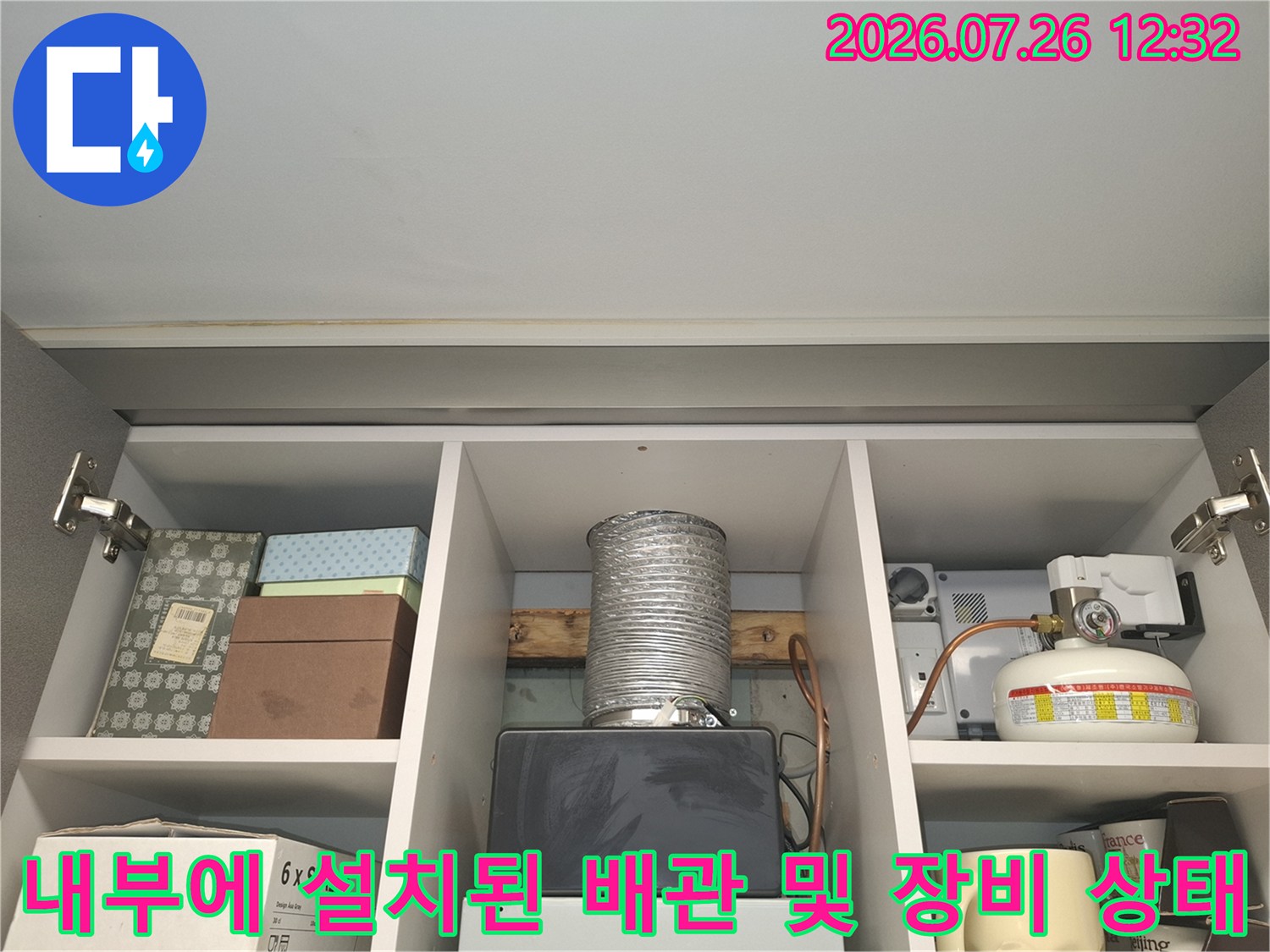 흰색-선반-칸막이-사이에-위치한-은색-배관과-보일러-제어-장치들