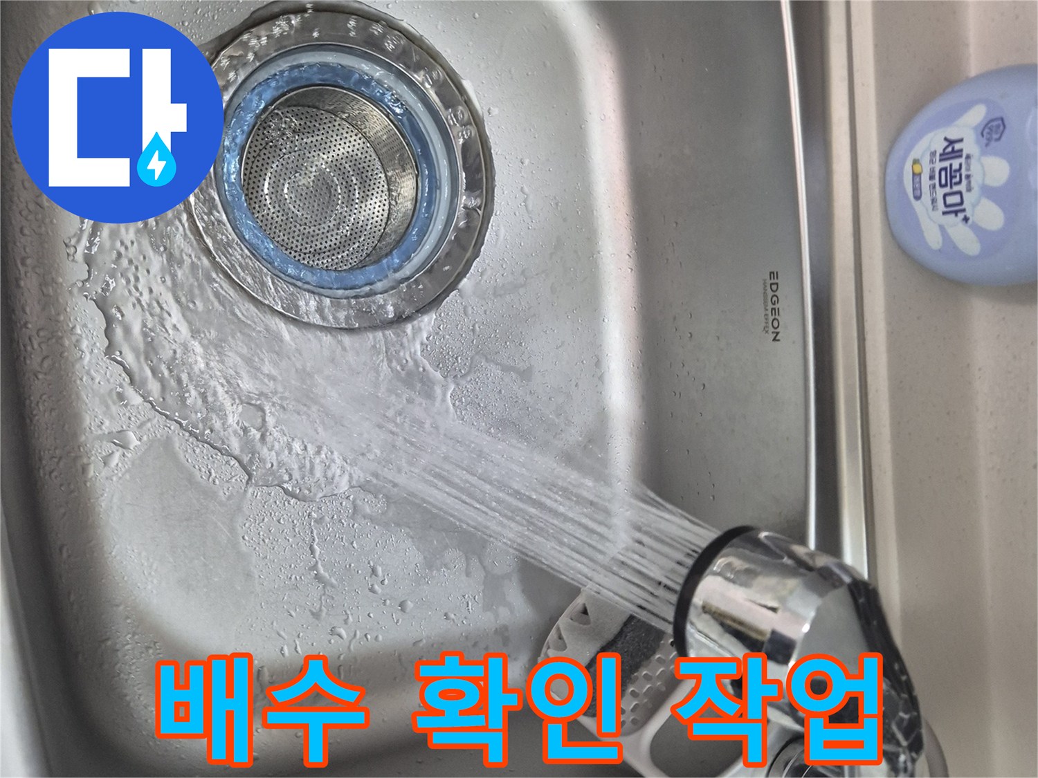 싱크대 수전에서 물을 틀어 배수 상태를 관찰하는 장면입니다.
